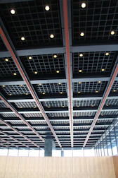 Suspended ceiling grid with sleek metal panels in a commercial interior.