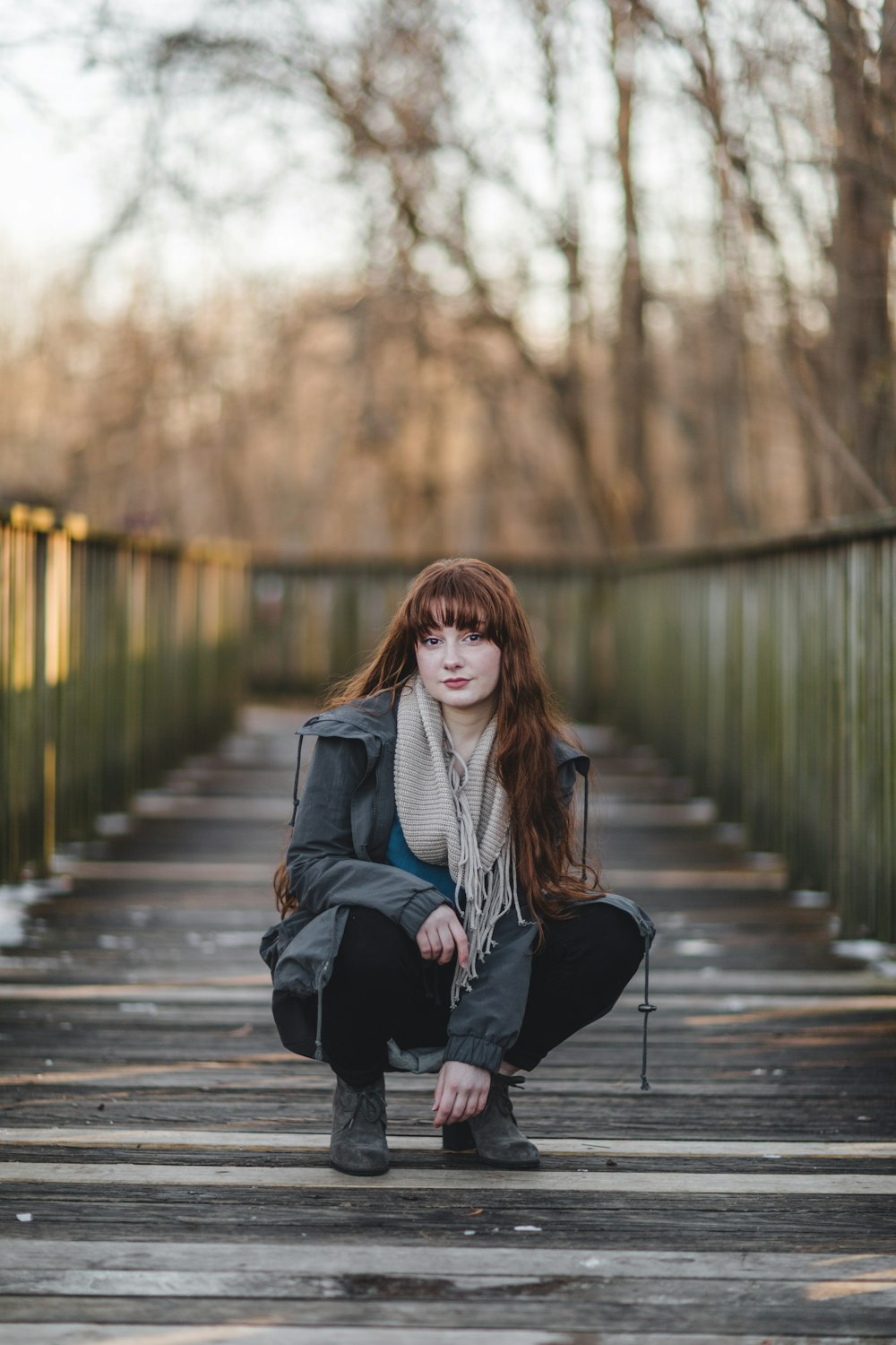 woman sitting on wooden bridge