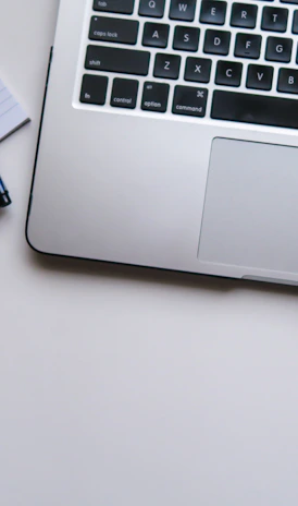 silver laptop computer beside white ruled paper