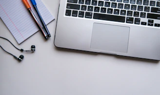silver laptop computer beside white ruled paper