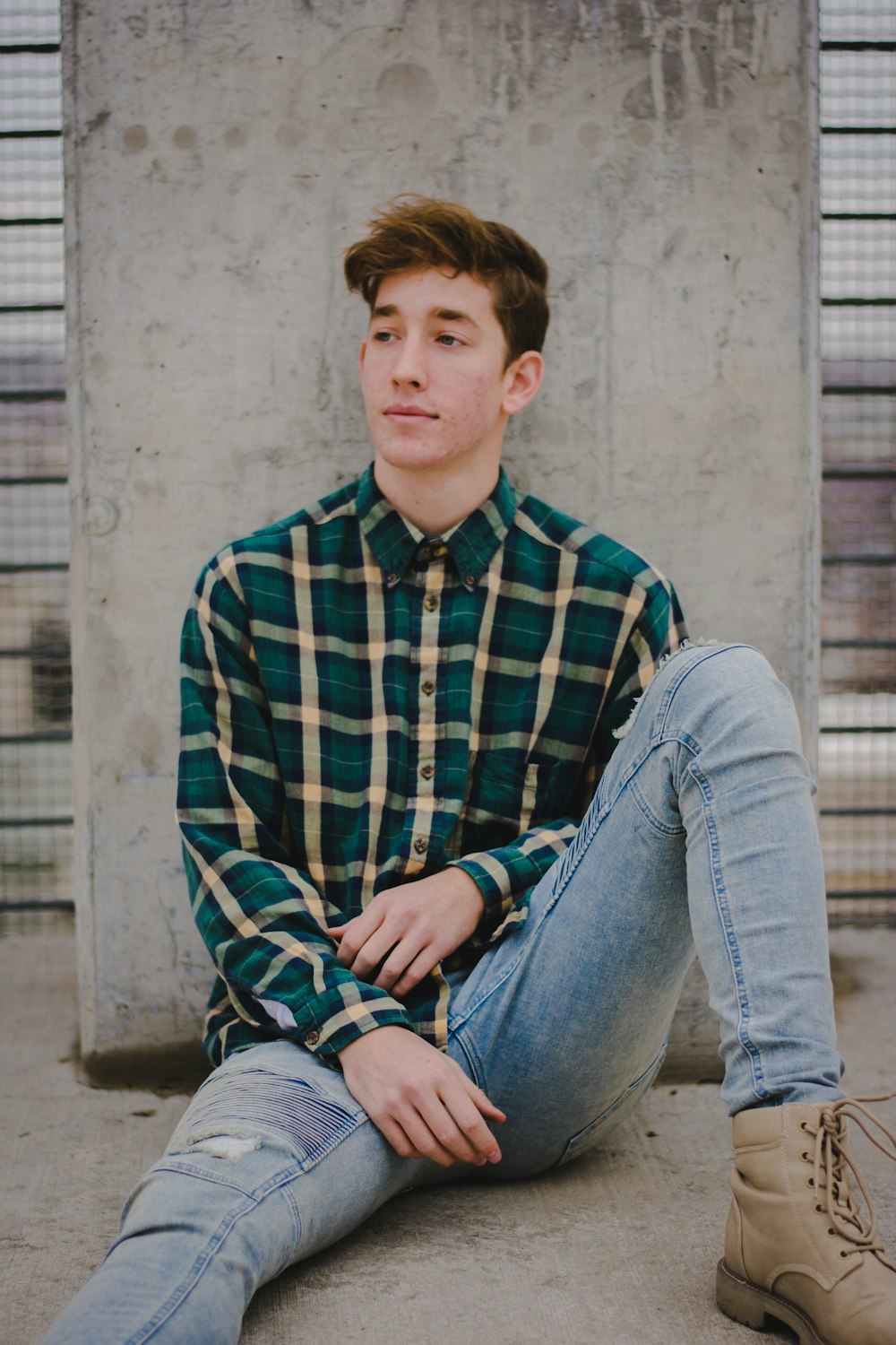 man sitting on floor while leaning on wall