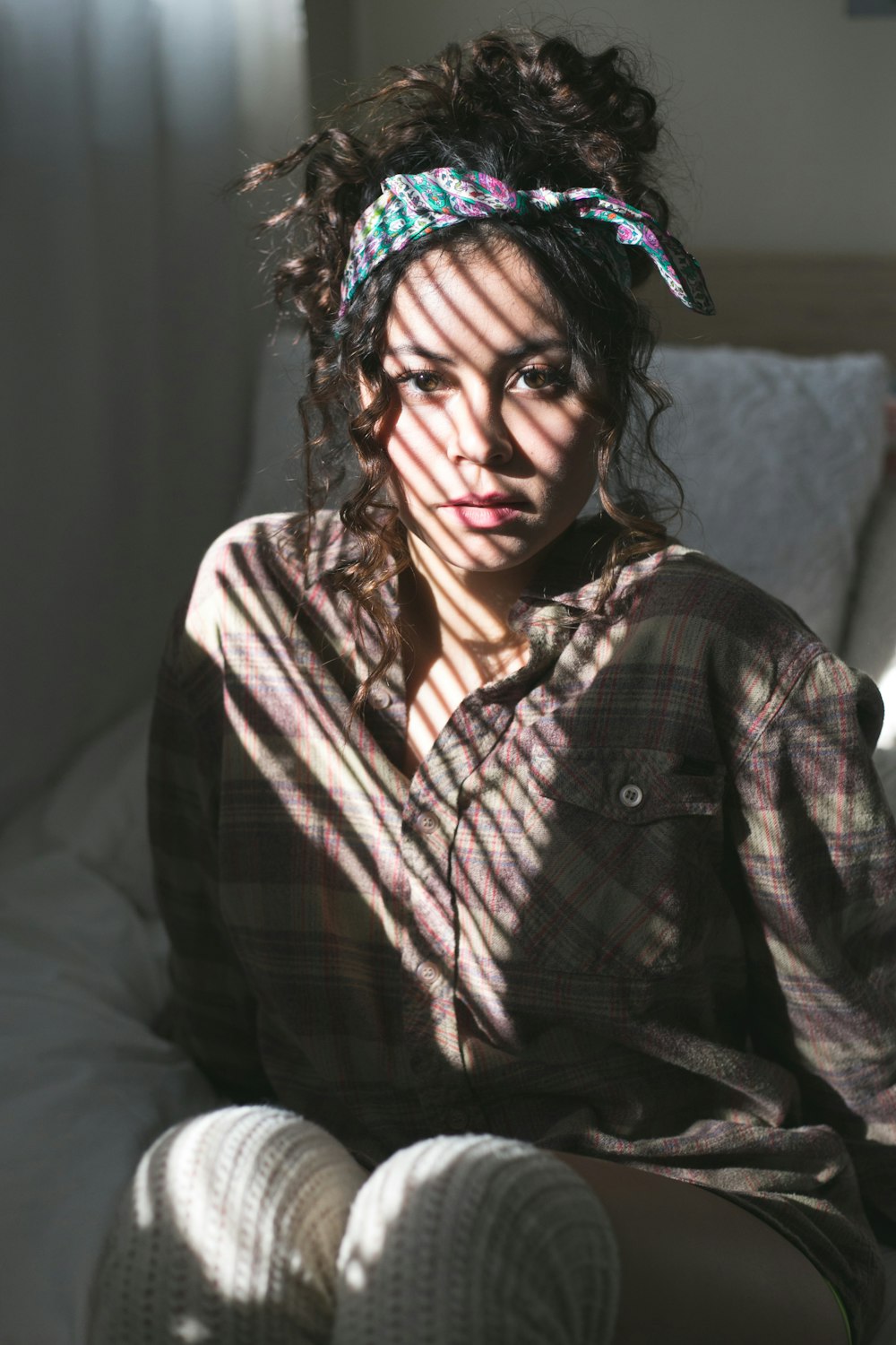 woman lying on white bed sheet during daytime