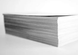 Stack of neatly organized policy research reports on a clean white desk.