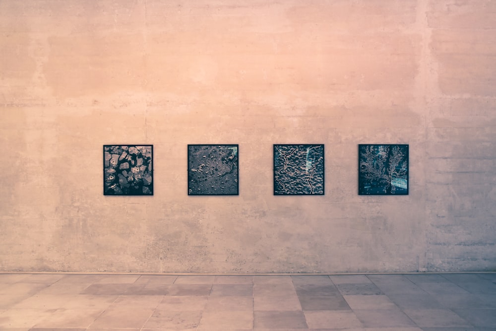 quatre arts muraux noirs sur un mur brun