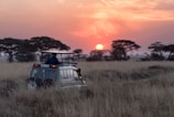 man riding on gray car during sunset