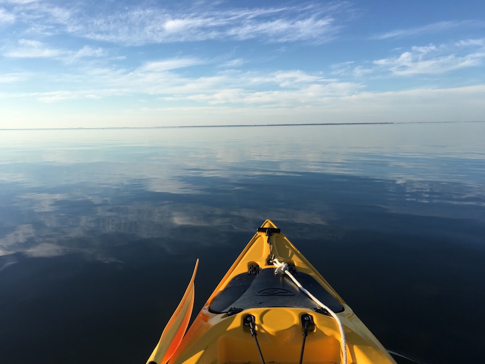 photography of yellow kayak sailing on body of water