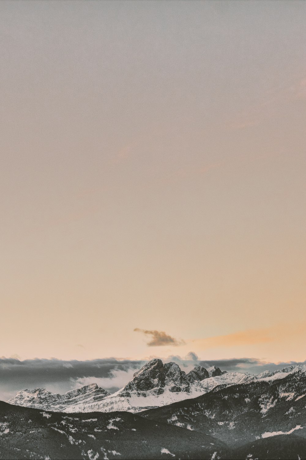 Formación rocosa cubierta de nieve bajo el cielo anaranjado