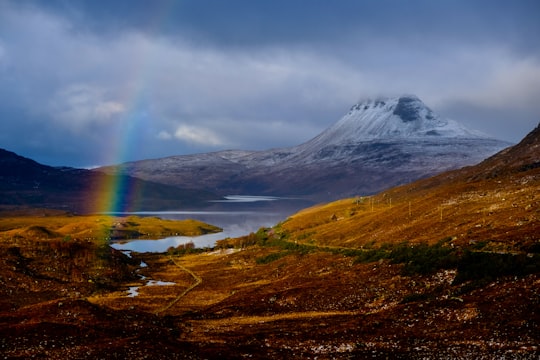 rainbow above brown field in Stac Pollaidh United Kingdom