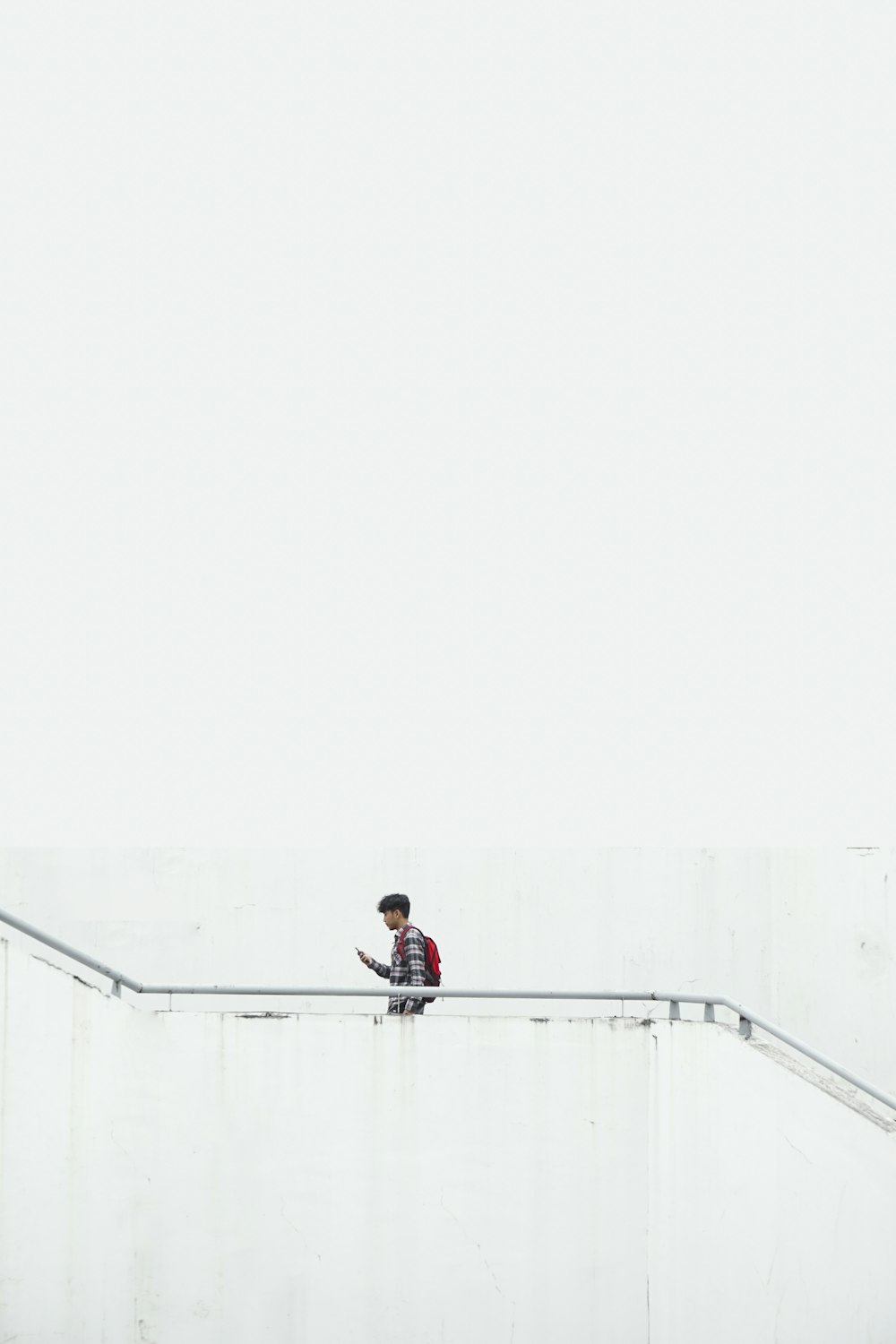 homme sur l’escalier portant un sac à dos rouge