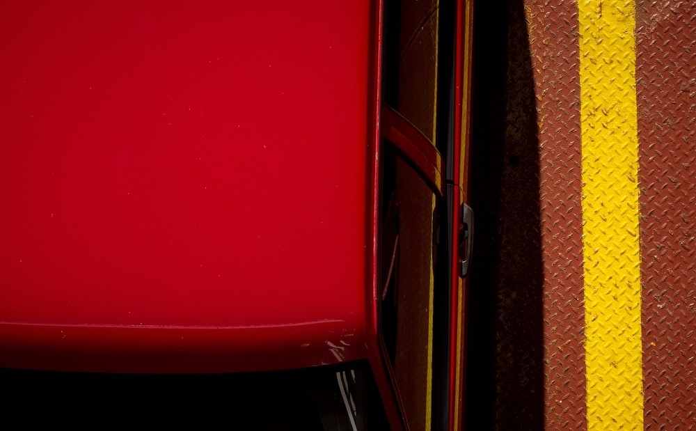 a red car parked next to a yellow line