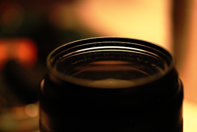 Close-up of a camera lens with soft natural background bokeh.