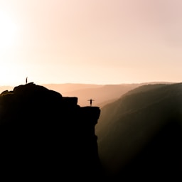 silhouette of person on cliff