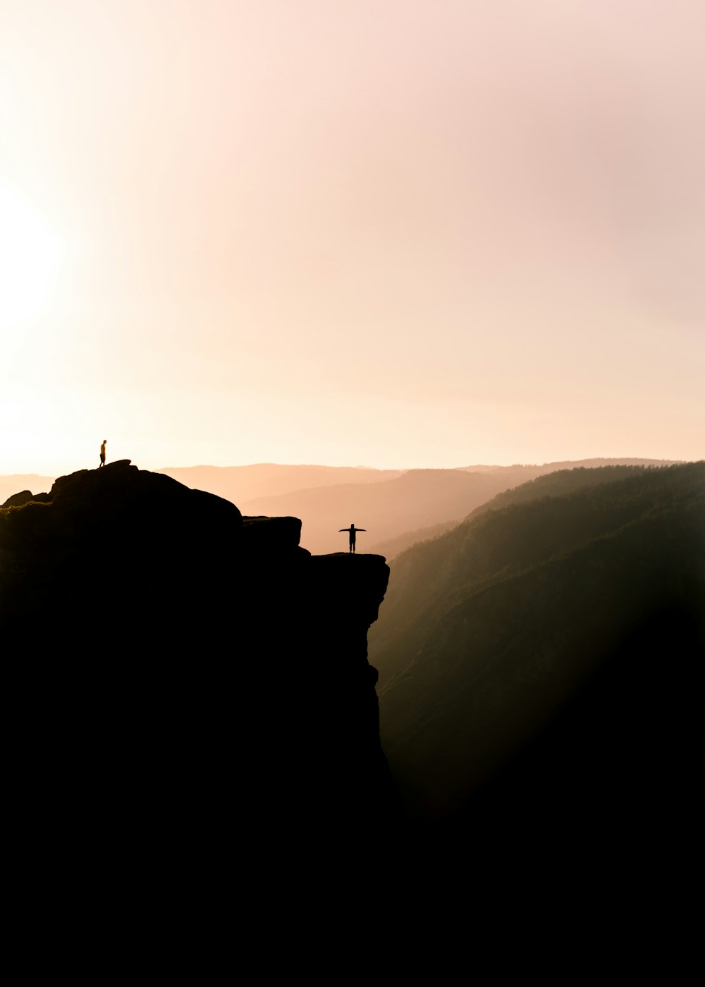 silhouette of person on cliff