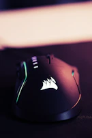 A modern green and black gaming mouse glowing softly in low light.