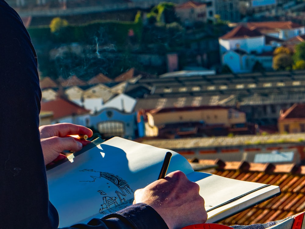 Mann skizziert Häuser auf dem Dach