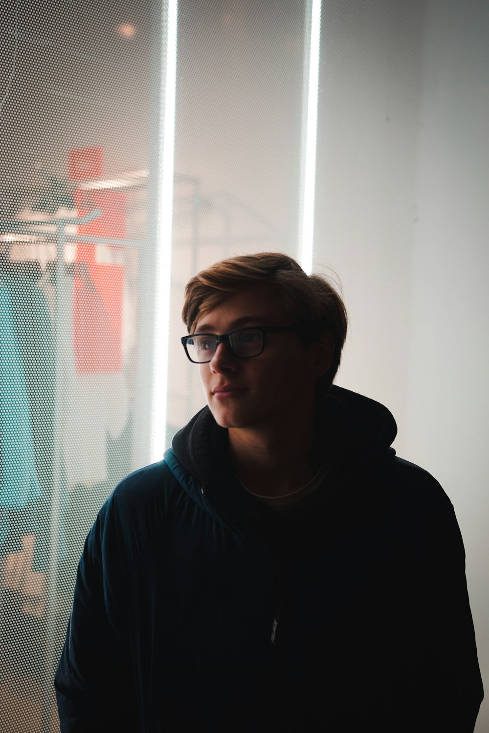 man standing near glass window