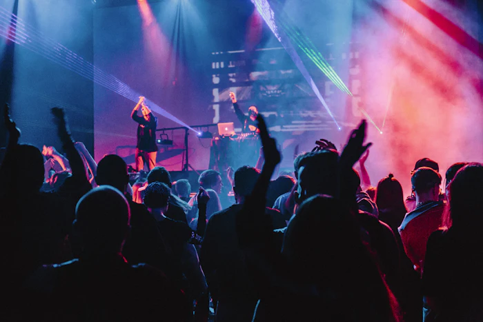 Crowd dancing under colorful stage lighting