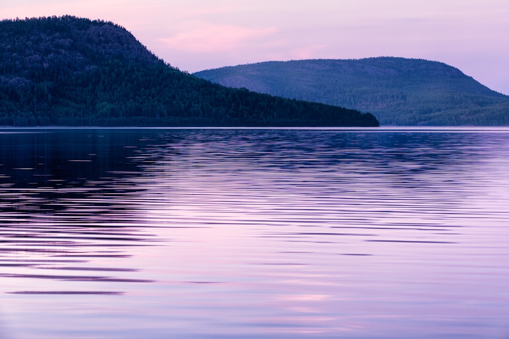 a large body of water with a mountain in the background