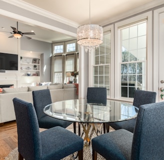 round clear glass-top table and five gray chairs dining se