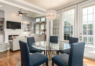 round clear glass-top table and five gray chairs dining se