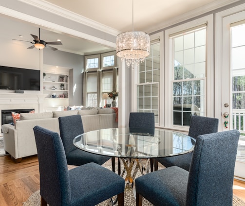 round clear glass-top table and five gray chairs dining se