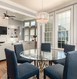 round clear glass-top table and five gray chairs dining se