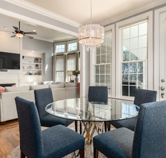 round clear glass-top table and five gray chairs dining se