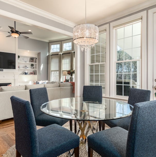 round clear glass-top table and five gray chairs dining se