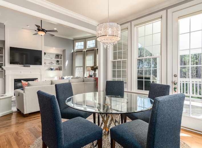 round clear glass-top table and five gray chairs dining se