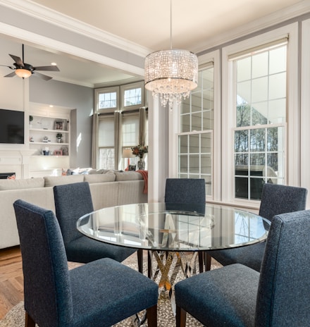 round clear glass-top table and five gray chairs dining se