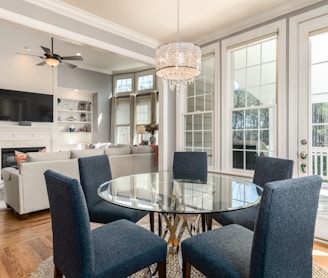 round clear glass-top table and five gray chairs dining se