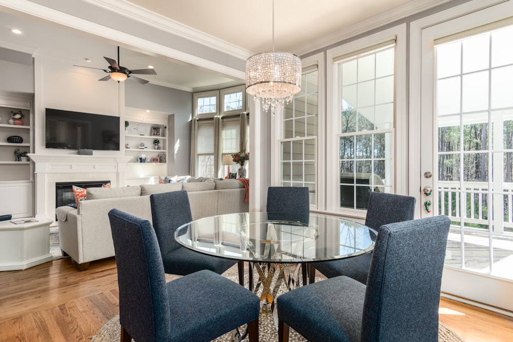 round clear glass-top table and five gray chairs dining se