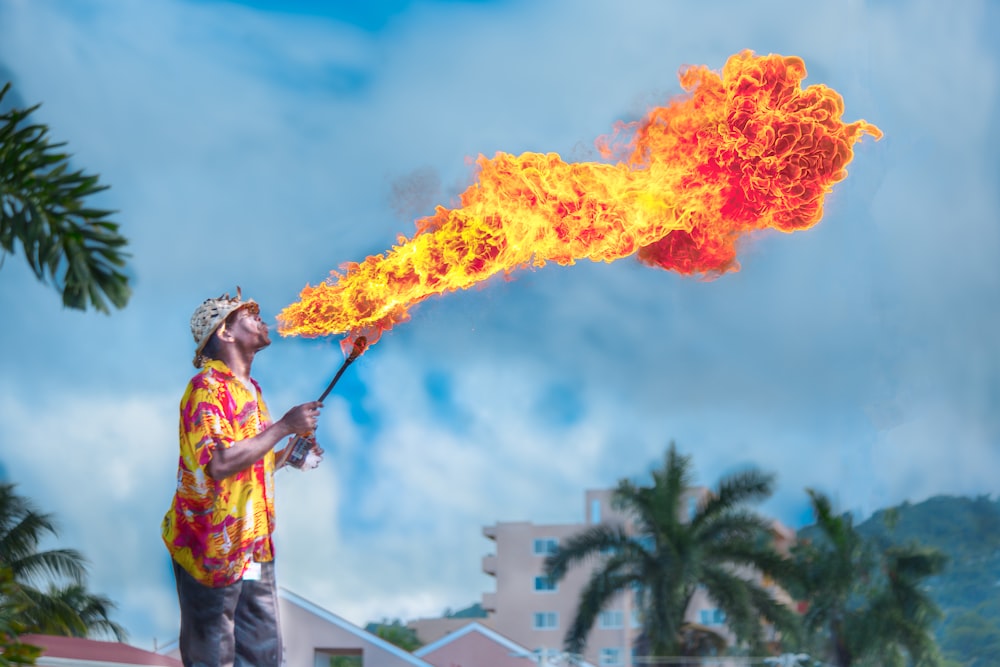 homme soufflant du gaz pour faire du feu