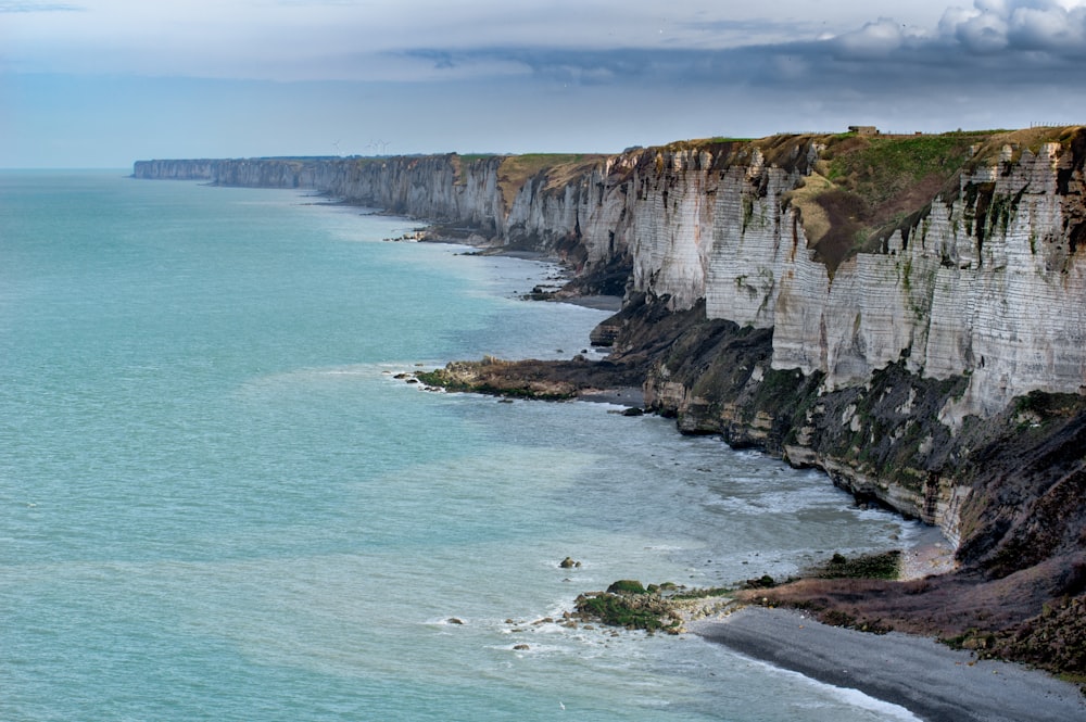 gray cliff near ocean in landscape photography