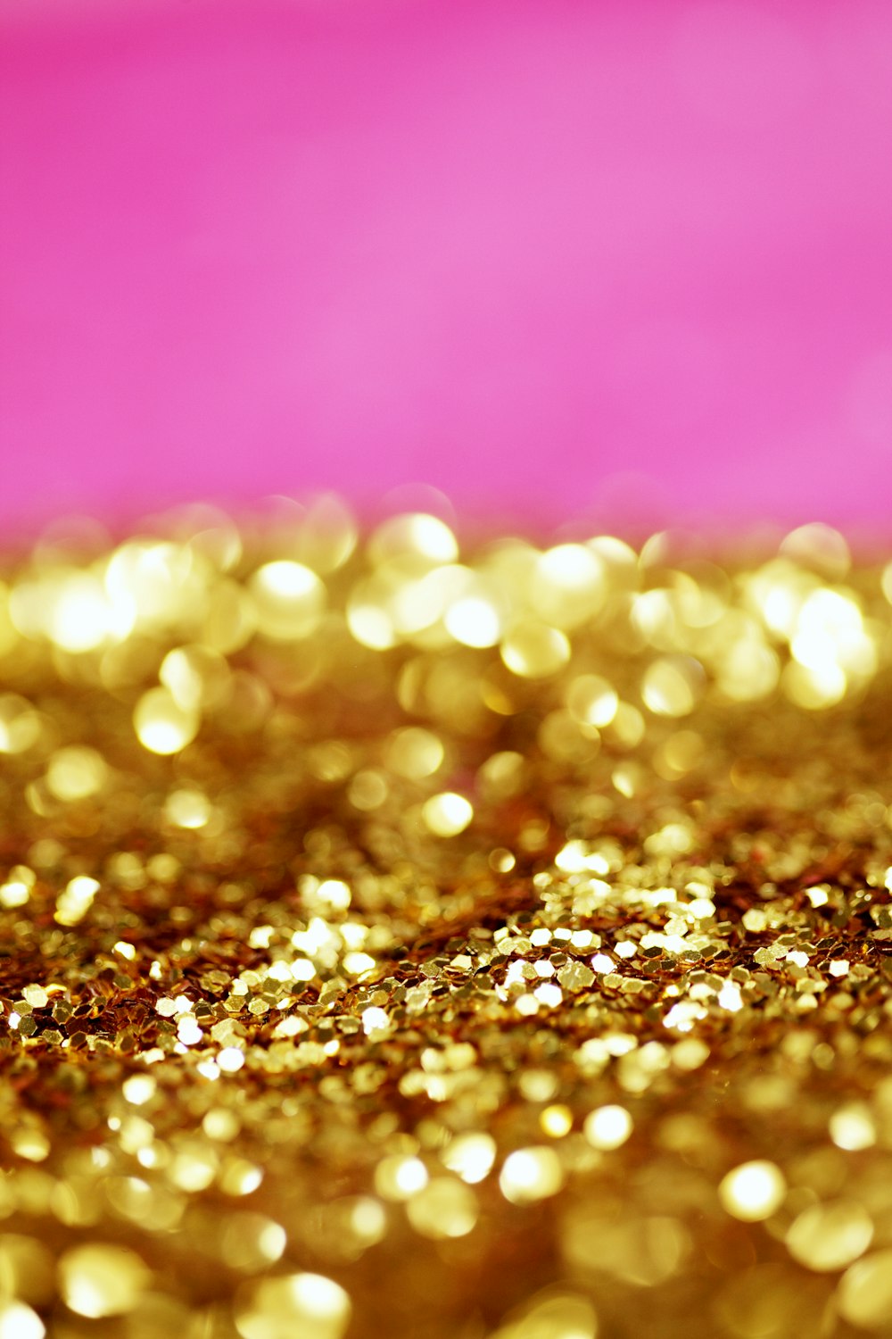 Un fond rose et or avec beaucoup de paillettes dorées