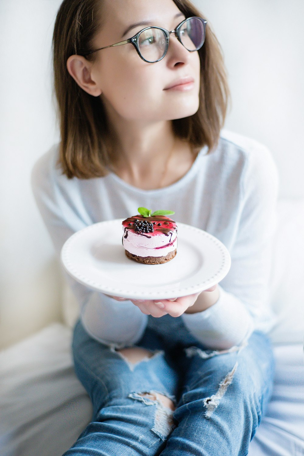 woman wearing white shirt holding plate of cake