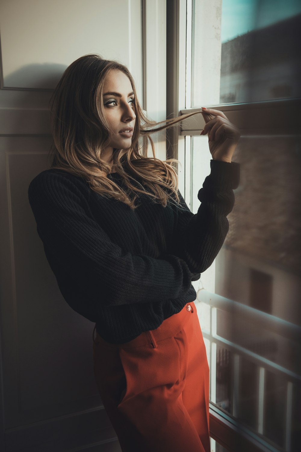 woman standing beside mirror