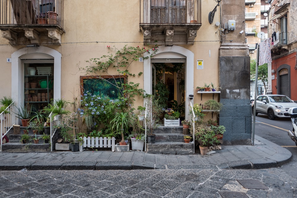 edifício de concreto bege com flores e plantas na porta