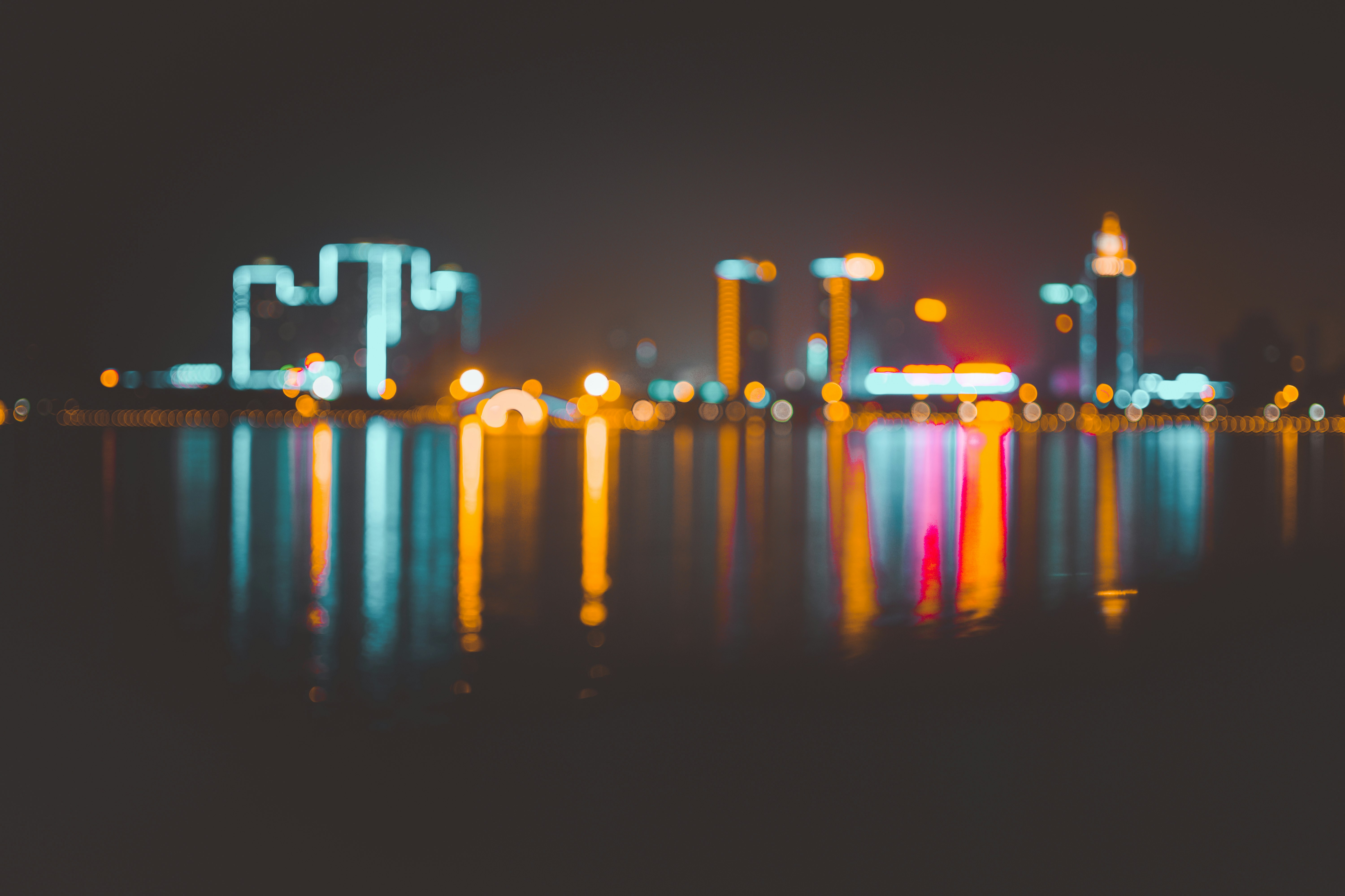 bokeh photography of cityscape on body of water