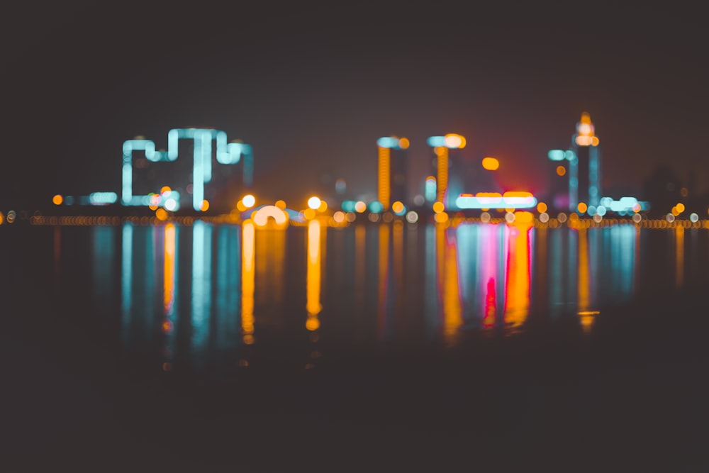 bokeh photography of cityscape on body of water