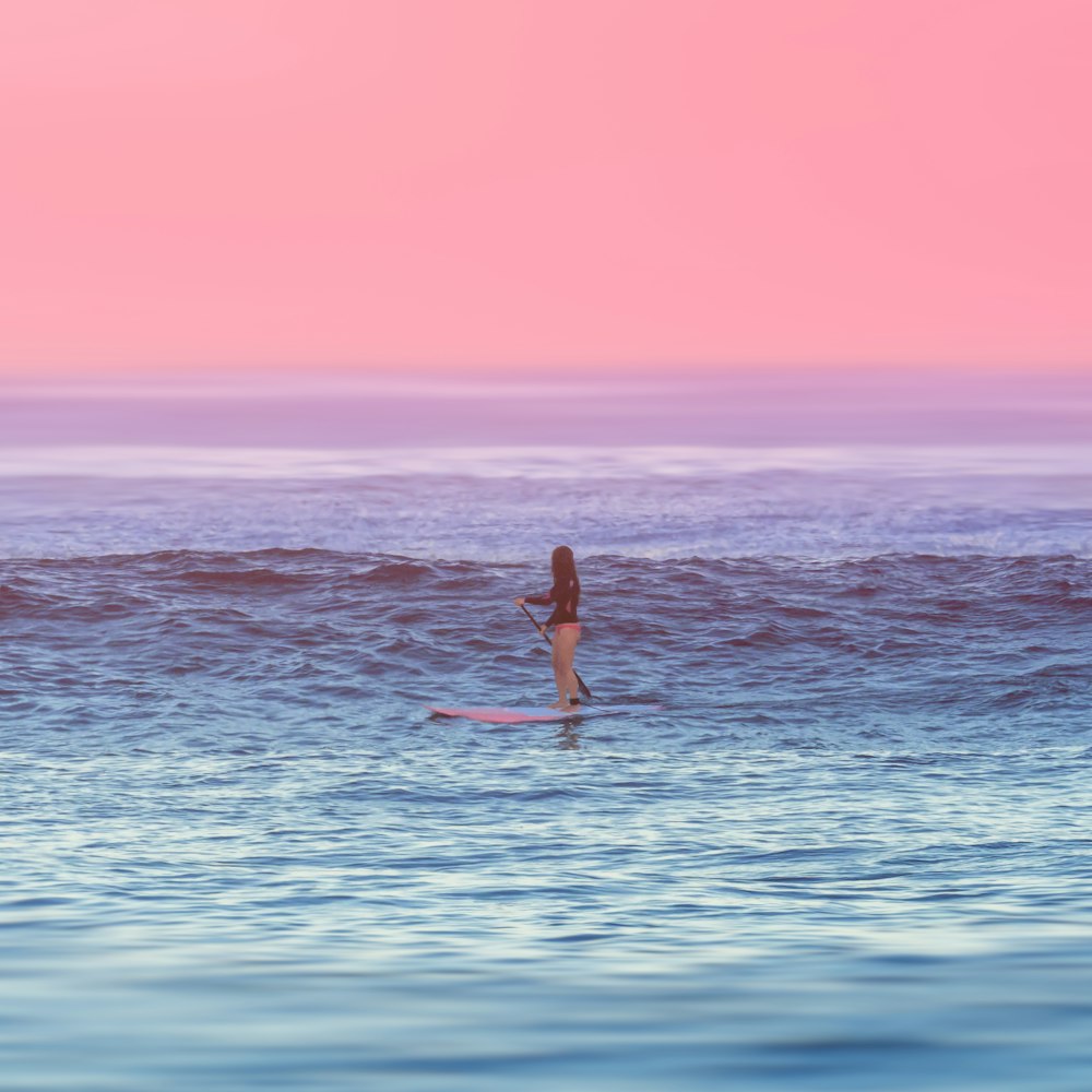 woman riding paddle boat at the middle of the ocean