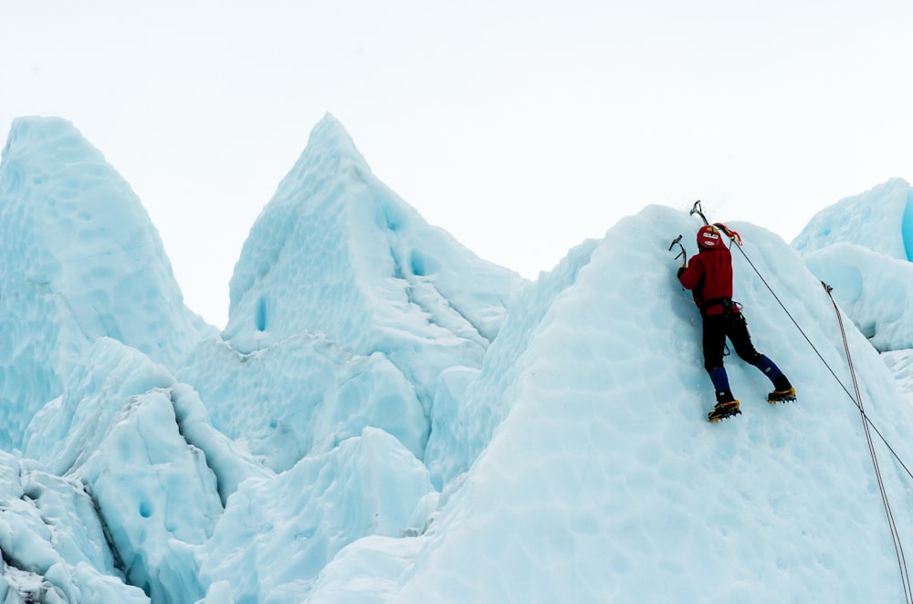 person climbing snowy mountain