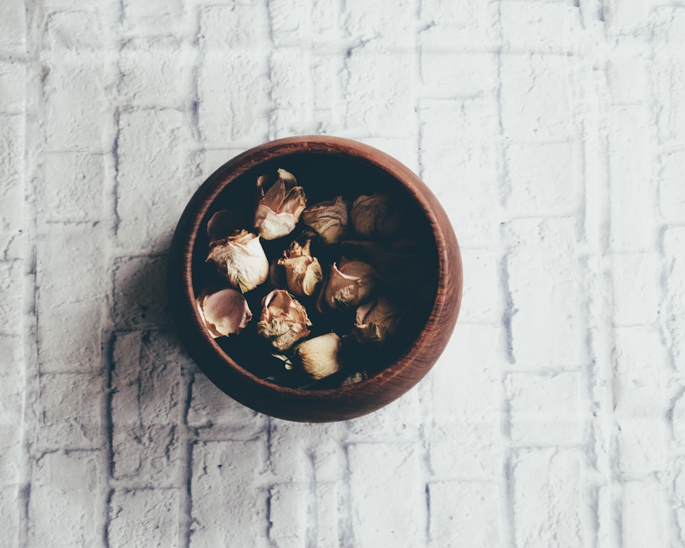 round brown wooden bowl on white brick