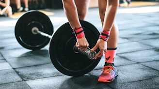 person locking gym plates on barbell