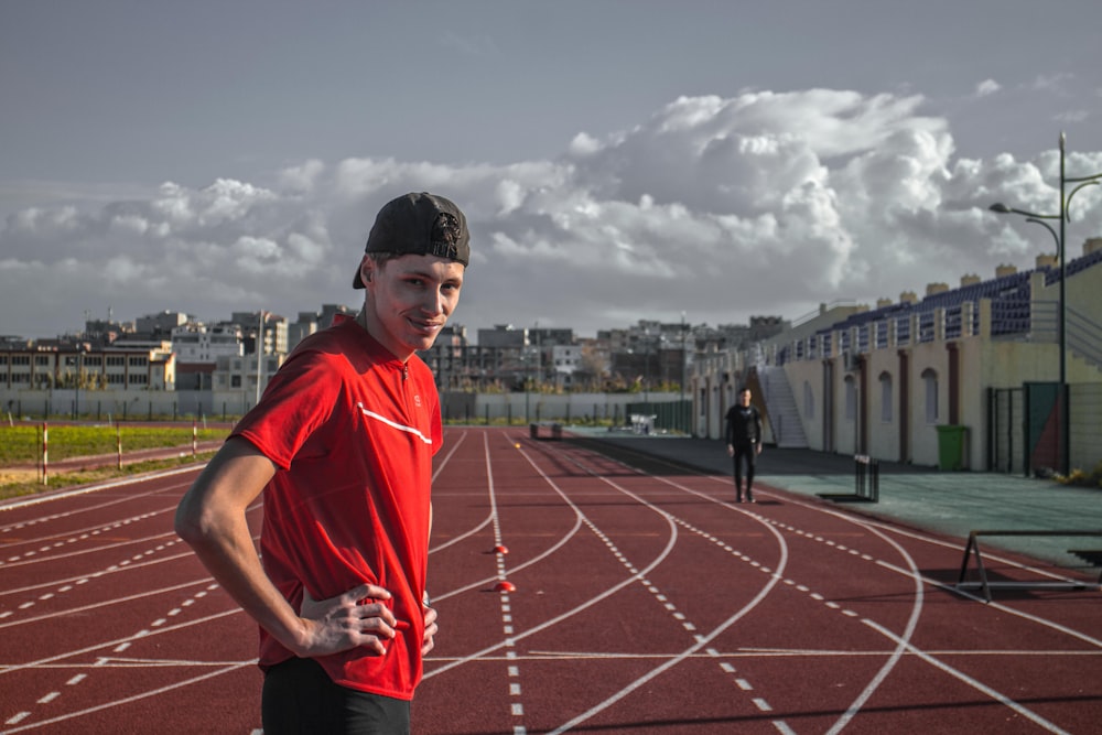 a man standing on a track with his hands on his hips