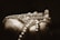 A hand gently holding a string of pearls, highlighted by soft lighting that creates a serene and elegant atmosphere. The pearls are prominently displayed, showcasing their smooth texture and spherical shape, while the background remains dark and blurred.