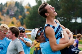 Group of diverse runners laughing together during an outdoor training session.