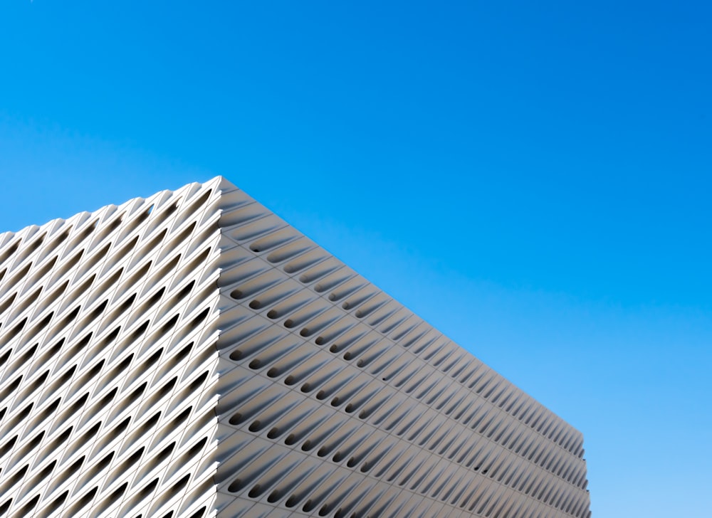 a tall white building with a blue sky in the background