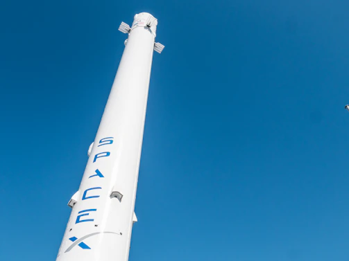 A sleek rocket illustration taking off against a clear blue sky with subtle stars.