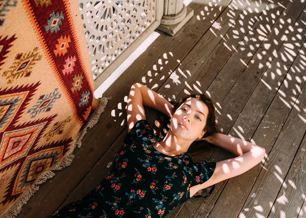 woman lying on brown wooden planks